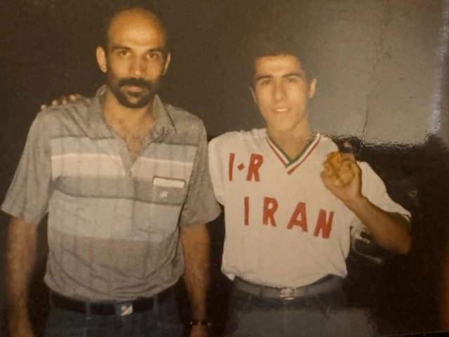Two people posing together, one wearing a white I.R. Iran sports jersey.