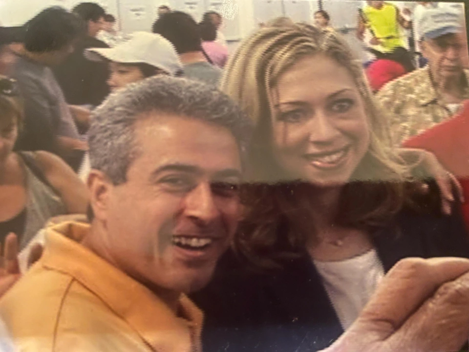 A man and a woman smile toward the camera at a gathering.