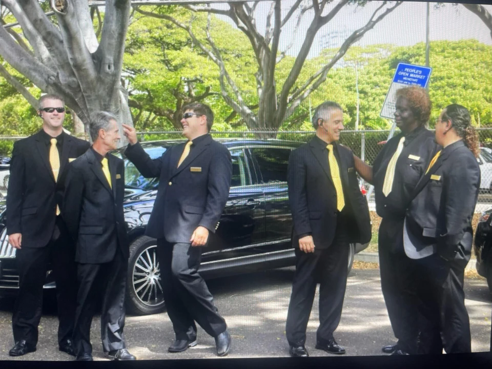 Royal Hawaiian Limousine chauffeurs standing beside a company vehicle