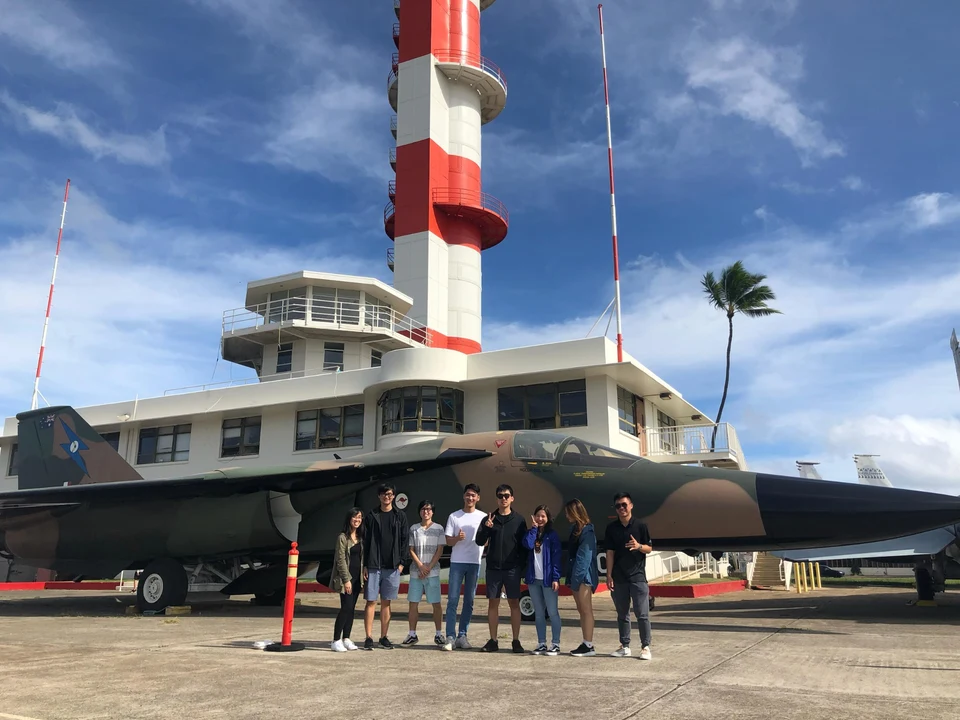 University of Hawaiʻi tourism students stand beside an aircraft at the Pearl Harbor Historic Site during an educational visit organized by Morad Shaker.
